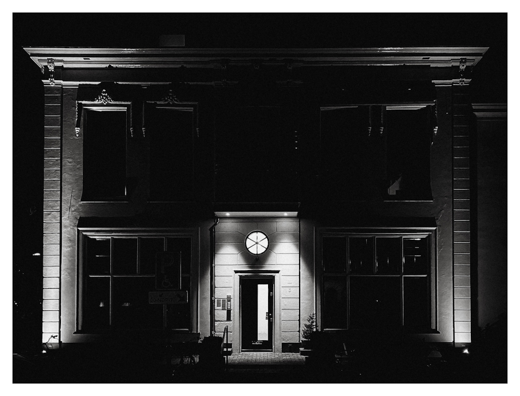 Facade of a classically styled building, in black and white. 