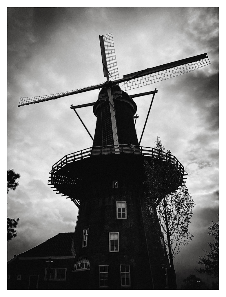Silhouet of a classic windmill against a cloudy sky. 