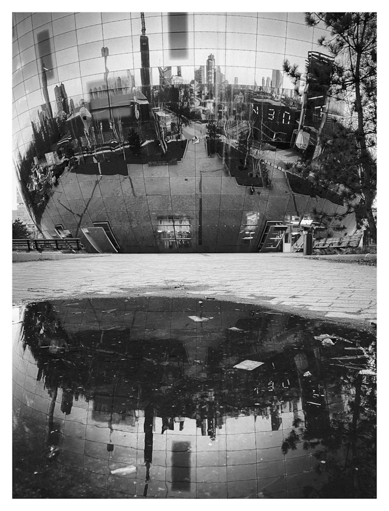 Reflectie van het Depot Boijmans Van Beuningen in een plas water, in zwart-wit. 